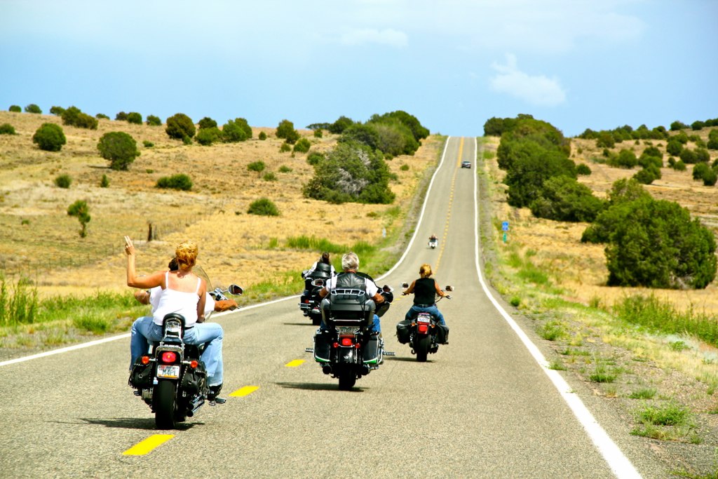 Waving from motorcycle on open road
